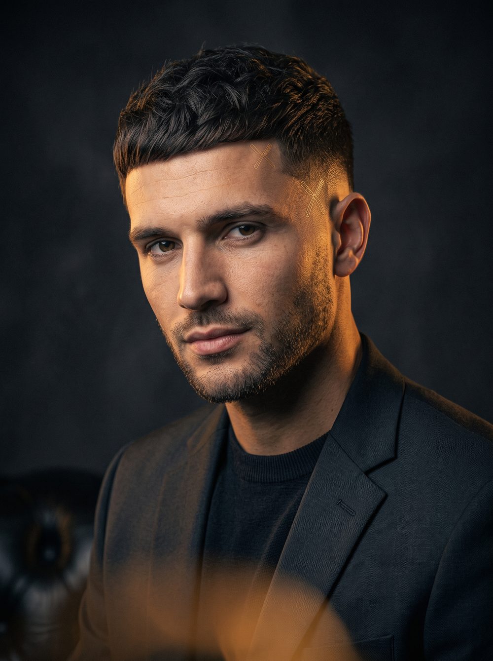 Editorial portrait of a handsome man with slick low fade haircut and clean hot towel shave finish